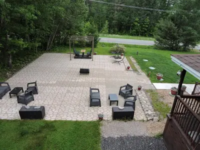 a patio with a group of chairs and a swing at Gite Passion et Tendresse B&B in Shefford