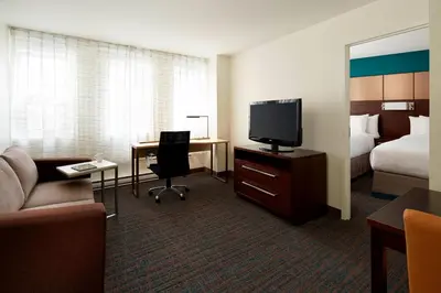 a hotel room with a bed and a desk with a television at Residence Inn by Marriott Montréal Downtown in Montréal