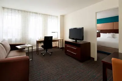 a hotel room with a bed and a desk with a television at Residence Inn by Marriott Montréal Downtown in Montréal