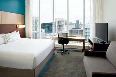 a hotel room with a bed and a desk and a television at Residence Inn by Marriott Montréal Downtown in Montréal