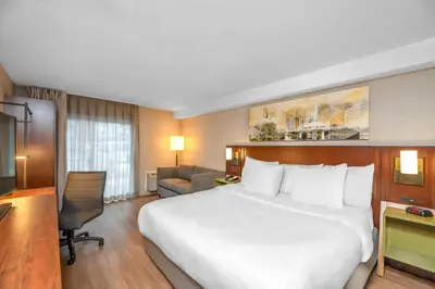 a hotel room with a large bed and a desk at Comfort Inn South Shore in Boucherville