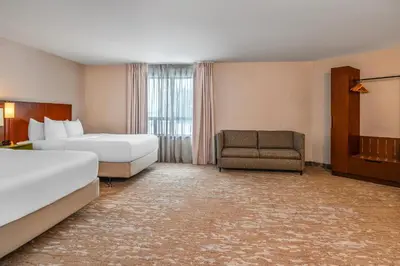 a hotel room with two beds and a chair at Comfort Inn South Shore in Boucherville