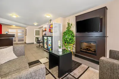 a living room with a fireplace and a flat screen tv at Comfort Inn South Shore in Boucherville
