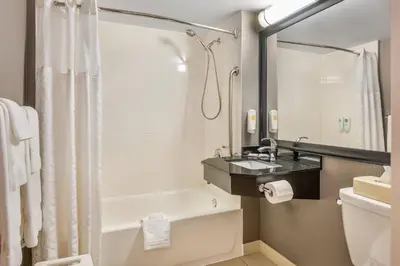 a bathroom with a tub and a sink and a toilet at Comfort Inn South Shore in Boucherville