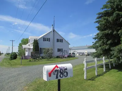 a white house with a sign in front of it at Gite Agricole Les Lilas in Saint Wenceslas