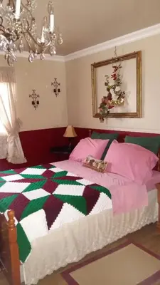 a bedroom with a bed with a colorful quilt at Gite Agricole Les Lilas in Saint Wenceslas