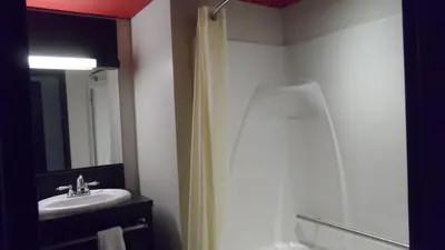 a bathroom with a shower curtain and a sink at Grand Hotel Times Sherbrooke in Sherbrooke
