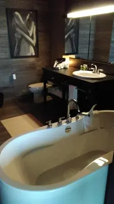 a bathroom with a bath tub and a sink at Grand Hotel Times Sherbrooke in Sherbrooke