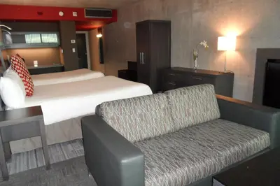 a hotel room with a bed and a couch at Grand Hotel Times Sherbrooke in Sherbrooke