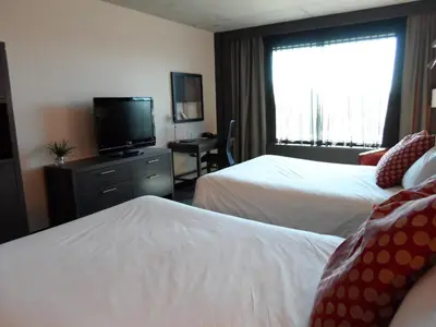 a hotel room with two beds and a flat screen tv at Grand Hotel Times Sherbrooke in Sherbrooke