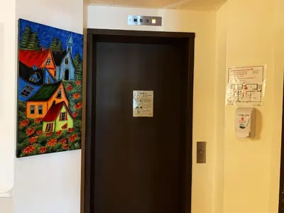 a painting of a house on the wall next to a door at Auberge du Grand Lac in Magog-Orford
