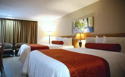 a hotel room with two beds and a couch at Auberge du Grand Lac in Magog-Orford