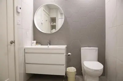 a bathroom with a white toilet and a mirror at Auberge du Grand Lac in Magog-Orford