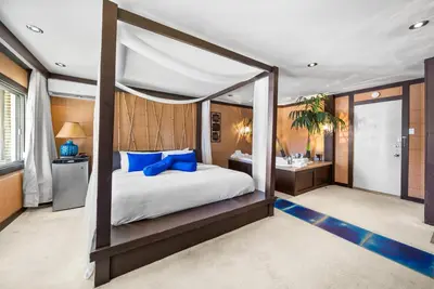 a bedroom with a canopy bed and a bathroom at Hotel-Motel Coconut in Trois-Rivières
