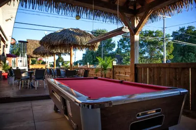 a pool table on a patio with a restaurant at Hotel-Motel Coconut in Trois-Rivières
