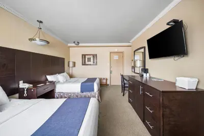 a hotel room with two beds and a flat screen tv at Hotel-Motel Coconut in Trois-Rivières