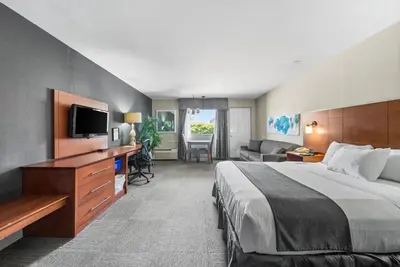 a hotel room with a bed and a living room at Hotel-Motel Coconut in Trois-Rivières