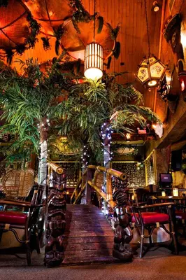 a restaurant with a wooden table and chairs and lights at Hotel-Motel Coconut in Trois-Rivières