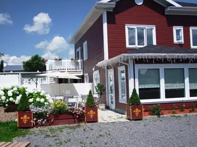 a red house with flowers in front of it at Motel Canadien in Trois-Rivières