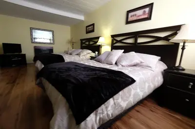 a bedroom with two beds with black and white sheets at Motel Canadien in Trois-Rivières