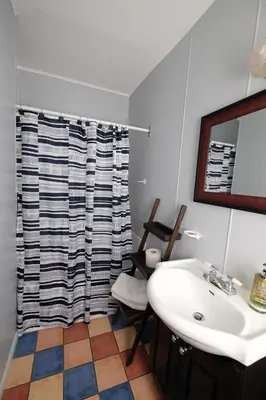 a bathroom with a sink and a shower curtain at Motel Canadien in Trois-Rivières