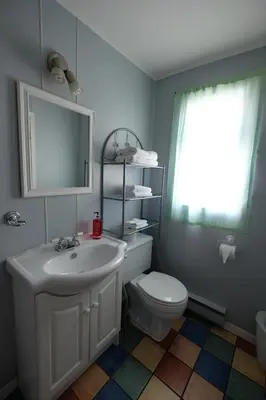 a bathroom with a sink and a toilet and a mirror at Motel Canadien in Trois-Rivières