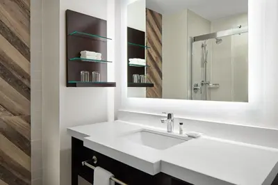 a bathroom with a white sink and a mirror at Delta Hotels by Marriott Sherbrooke Conference Centre in Sherbrooke