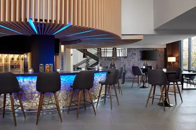 a bar in a hotel lobby with black stools at Delta Hotels by Marriott Sherbrooke Conference Centre in Sherbrooke