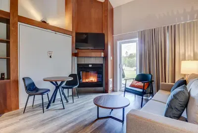 a living room with a couch and chairs and a fireplace at Estrimont in Magog-Orford