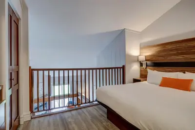 a hotel room with a bed and a balcony at Estrimont in Magog-Orford