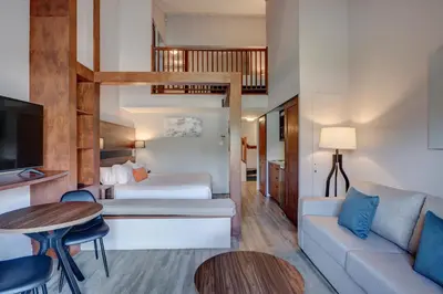 a hotel room with a bed and a couch at Estrimont in Magog-Orford
