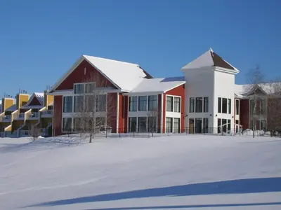a large red and white building in the snow at Estrimont in Magog-Orford