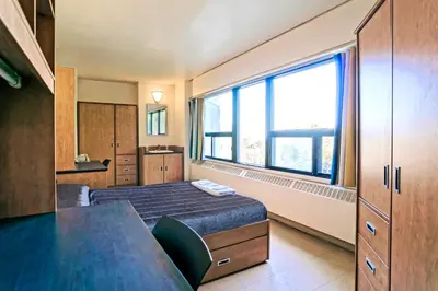 a bedroom with a bed and a large window at ZUM MTL Auberge d'été - Université de Montréal in Montréal