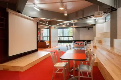 a classroom with tables and chairs and a large screen at ZUM MTL Auberge d'été - Université de Montréal in Montréal