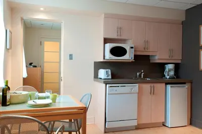 a kitchen with a table and a microwave at ZUM MTL Auberge d'été - Université de Montréal in Montréal
