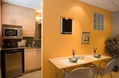 a kitchen with a table with chairs and a microwave at ZUM MTL Auberge d'été - Université de Montréal in Montréal