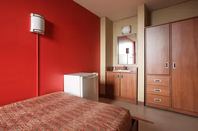 a red room with a bed and a sink at ZUM MTL Auberge d'été - Université de Montréal in Montréal