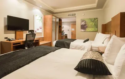 a hotel room with two beds and a flat screen tv at Hotel & Suites Le Dauphin Drummondville in Drummondville