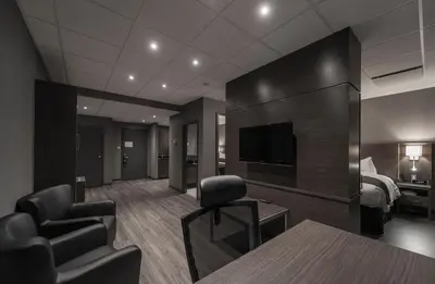 a hotel room with a bed and a television at Hotel & Suites Le Dauphin Drummondville in Drummondville
