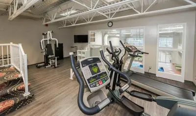 a gym with two treadmills and a treadmill at Hotel & Suites Le Dauphin Drummondville in Drummondville