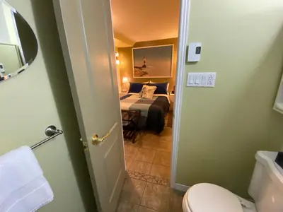 a bathroom with a room with a bed and a room with a bed sqor at Martine & Michel in Boucherville