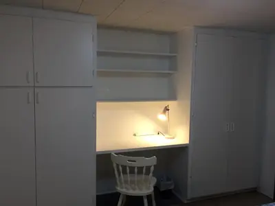 a room with a desk with a chair and a lamp at Martine & Michel in Boucherville