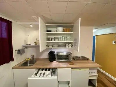 a kitchen with white cabinets and a counter with a microwave at Martine & Michel in Boucherville
