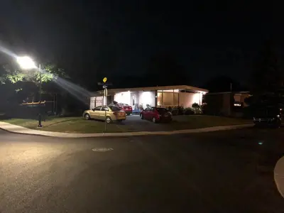 two cars parked in front of a house at night at Martine & Michel in Boucherville