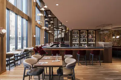 a restaurant with tables and chairs and a bar at Metcalfe Hotel Montréal by Gray Collection in Montréal