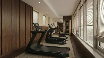 a gym with cardio machines in a room with wood walls at Metcalfe Hotel Montréal by Gray Collection in Montréal