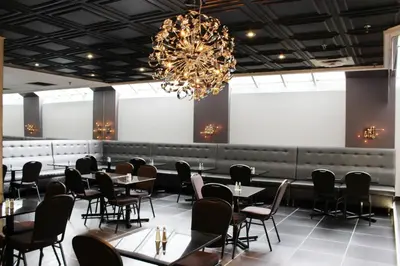 a dining room with tables and chairs and a chandelier at LELUX Hotel in Montréal