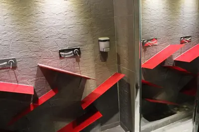 a bathroom with red shelves and a glass door at LELUX Hotel in Montréal