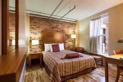 a hotel room with a bed and a brick wall at Hotel Quartier des Spectacles in Montréal