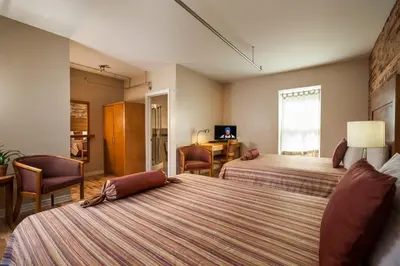 a hotel room with two beds and a desk at Hotel Quartier des Spectacles in Montréal